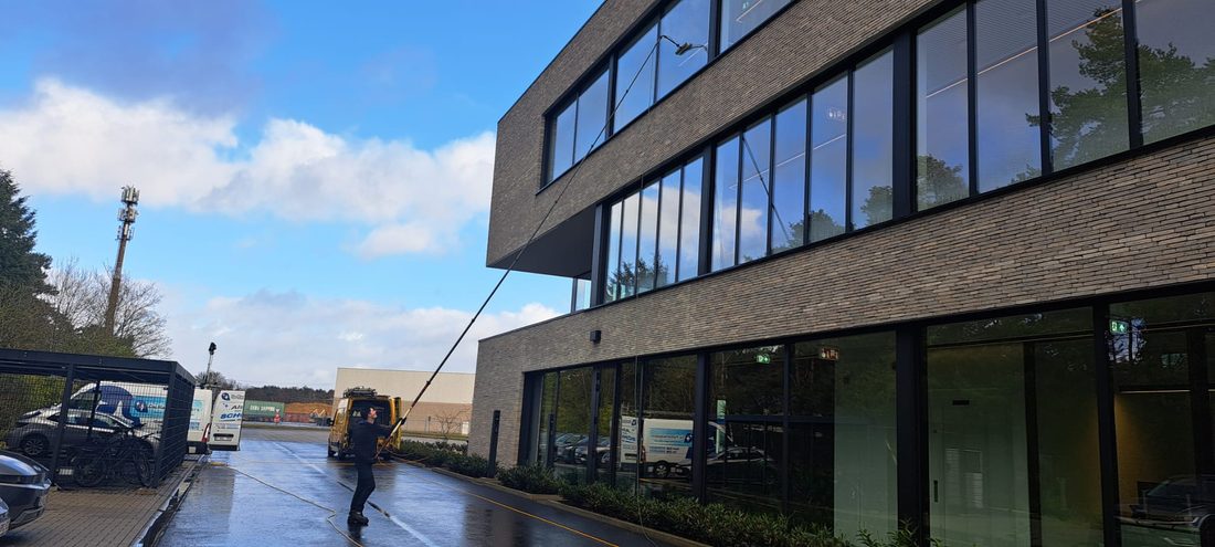 Ramen wassen met een telescoopstok aan een kantoorgebouw